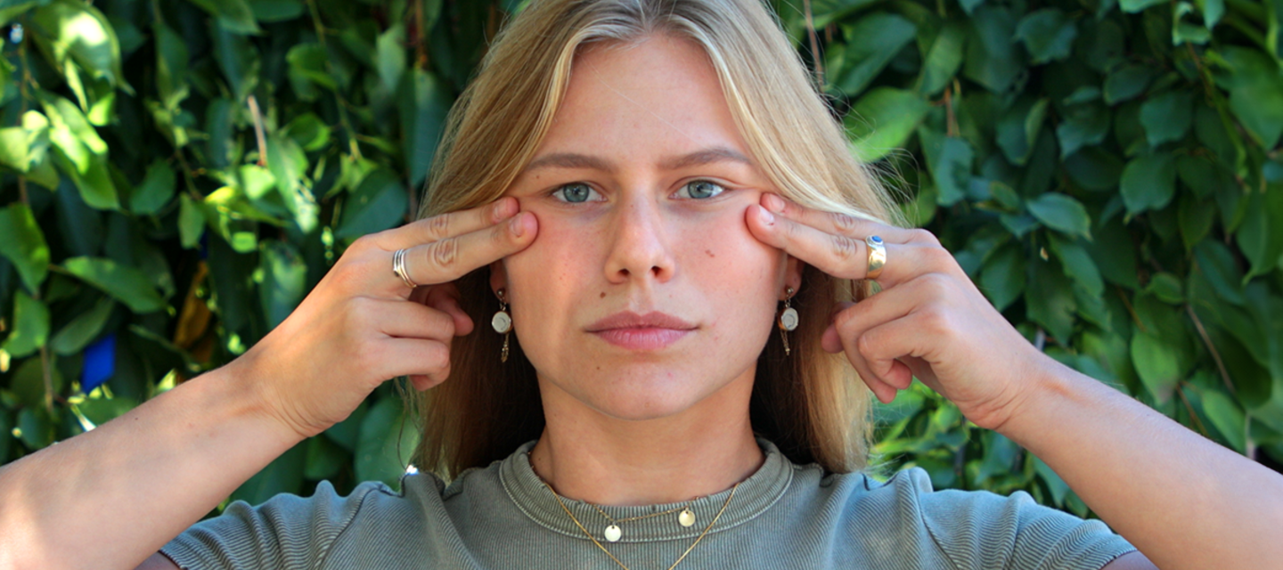 Five face yoga methods for a fresher, plumper face A model doing face yoga with fingertips on her cheekbones